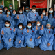 Medical staff makes a three finger salute with a red ribbons on their uniform at the Yangon General Hospital in Yangon on February 3, 2021.